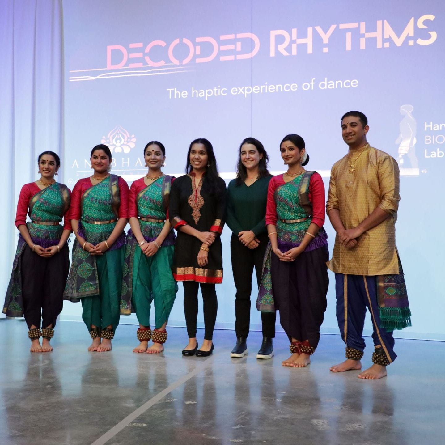 group of dancers posing for picture in front of "Decoded Rhythms" projected title slide